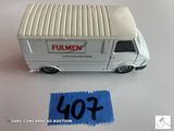 un camion miniature posé à côté d'une feuille de papier