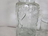 a glass jar with a cookie in it next to a glass jar with a cookie in it