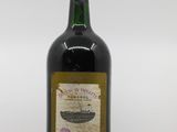 une vieille bouteille de vin posée sur une table en bois