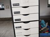 a tall black and white filing cabinet in a room