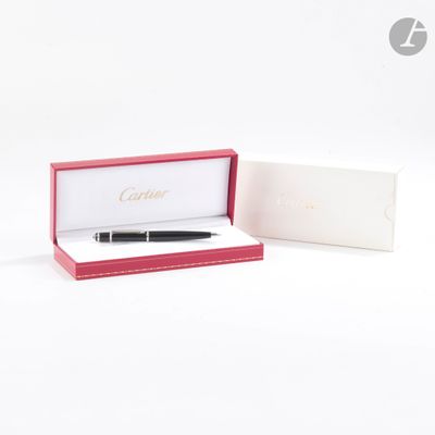 une photo d'un stylo dans une boîte posée sur une surface blanche