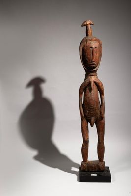 a wooden statue of a man with a bird on his head