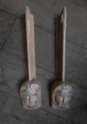 deux cuillères en bois ornées de visages, posées sur une table