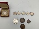 un assortiment d'objets en argent et de pièces d'argent dans un écrin rouge
