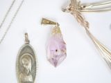 a picture of a necklace, a pendant, and a spoon on a table