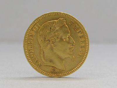 gros plan d'une pièce d'or sur une surface blanche