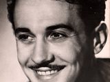 black and white photograph of a smiling man with a mustache