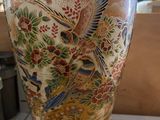 a vase with a bird on it sitting on a table