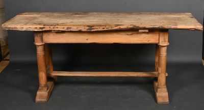 an old wooden table sitting on top of a black floor