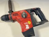 a red and black drill on a white surface