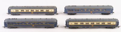 four blue and gold train cars sitting on top of a white surface