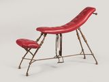 une photo d'un fauteuil en cuir rouge avec un repose-pieds