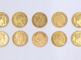 several gold coins are arranged in a row on a white surface