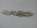 several cups and saucers are lined up on a white surface