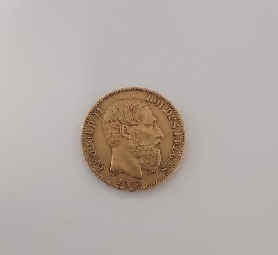 a close up of a gold coin on a white surface