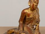 an image of a statue of a person sitting on the ground