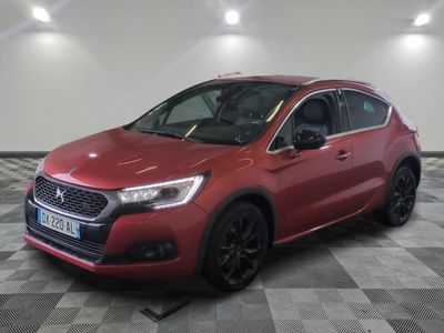 une voiture rouge est garée dans une pièce au sol en damier