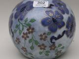 a small blue vase with flowers on it on a white surface