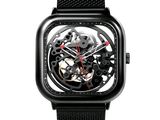 un gros plan d'une montre noire dotée d'un bracelet en maille noire