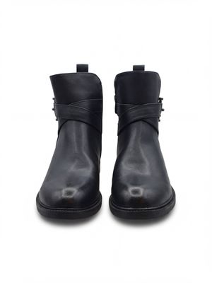 une paire de bottines en cuir noir avec des boucles, sur fond blanc