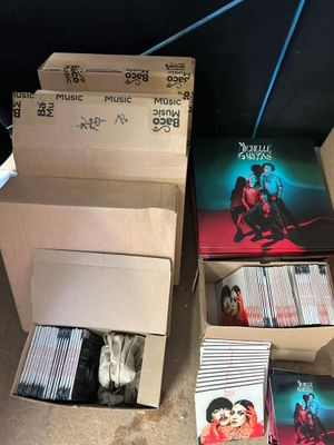 de nombreux CD rangés dans une boîte posée par terre, les uns à côté des autres
