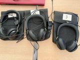 several headphones are lined up on a table next to a laptop