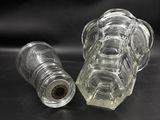 two empty glass bottles sitting next to each other on a table
