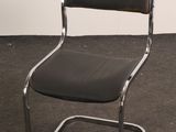 a black chair with a chrome frame and a black seat