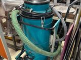 un aspirateur bleu posé au milieu d'une pièce