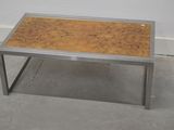 une table en métal avec un plateau en bois posée sur un sol en béton