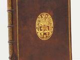 un vieux livre brun portant un emblème doré