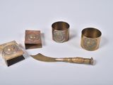 several brass objects including a knife, napkin, and napkin holder