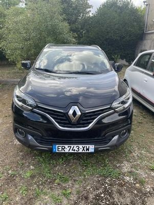 une voiture noire garée à côté d'une voiture blanche dans une cour