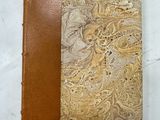 un gros plan sur un livre marron et beige à la couverture en cuir
