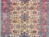 an antique persian rug with a floral design on a cream ground