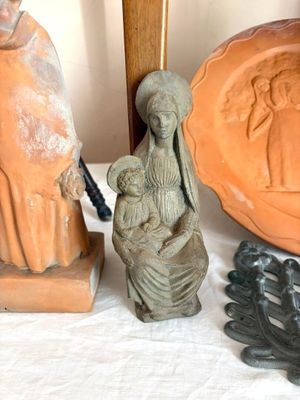 une statue représentant une femme tenant un enfant dans ses bras, à côté d'une statue représentant un homme