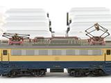 a yellow and blue train on the tracks next to other trains