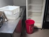 an image of a kitchen with a refrigerator and a trash can