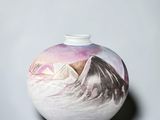 a white vase with a picture of a mountain on it