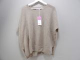 the sweater is hanging on a hanger on a white wall