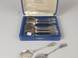 an assortment of silverware including spoons and spoons in a blue case