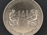 l'image d'une pièce d'argent sur laquelle figurent un homme et une femme assis à une table
