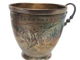a silver cup with a floral design on it