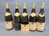 six bouteilles de vin sont alignées sur une table