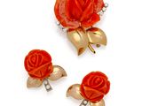 trois broches rouges et dorées sur fond blanc