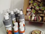 many bottles of paint sitting on a table next to a box of cookies