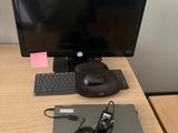 a desk with a monitor, keyboard, mouse and headphones on it