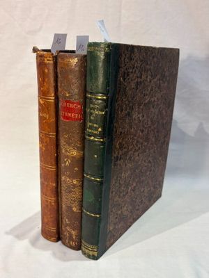 three books are stacked on top of each other on a white surface