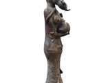 statue of a woman holding a baby and a goat on her back