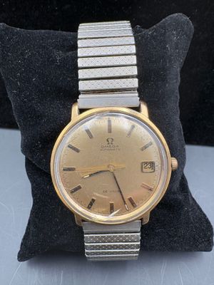 an image of a gold and silver wrist watch on a black pillow